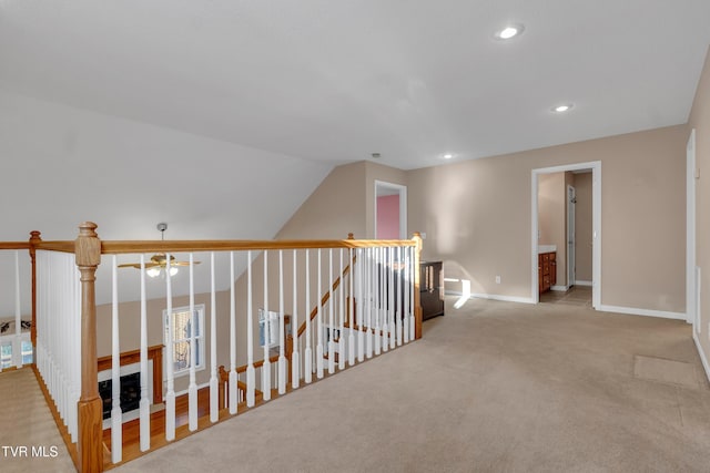 hall with vaulted ceiling and light colored carpet