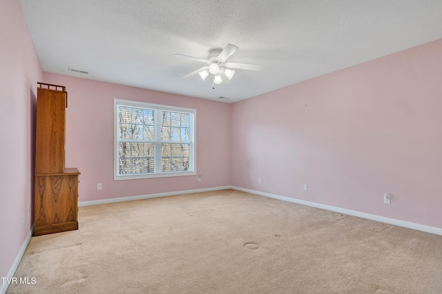 carpeted empty room with a textured ceiling and ceiling fan