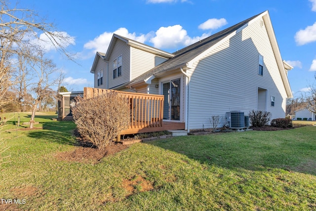 view of property exterior featuring a wooden deck, central AC unit, and a lawn