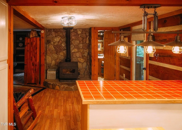 interior space featuring hardwood / wood-style flooring, a textured ceiling, and a wood stove