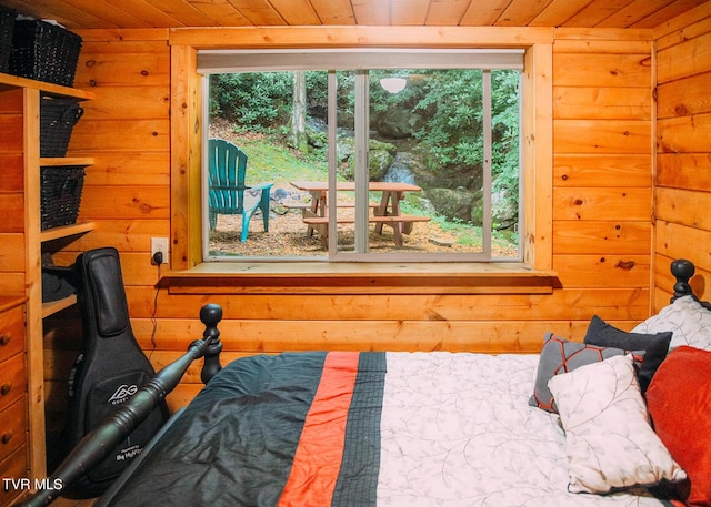 bedroom featuring wood ceiling and log walls