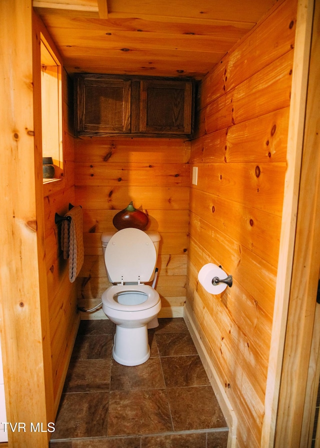 bathroom featuring wooden ceiling, toilet, and wood walls