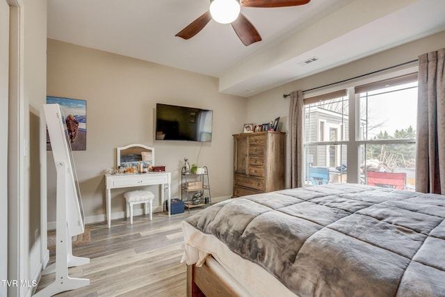 bedroom featuring ceiling fan, light wood-type flooring, visible vents, and baseboards