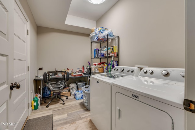 washroom featuring washer and dryer, laundry area, and light wood finished floors