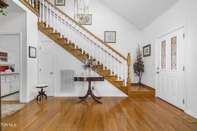 entryway featuring hardwood / wood-style flooring and high vaulted ceiling