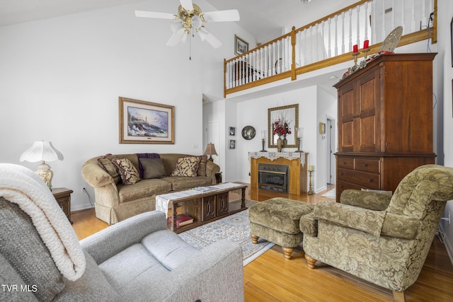 living room featuring wood-type flooring, high vaulted ceiling, and ceiling fan