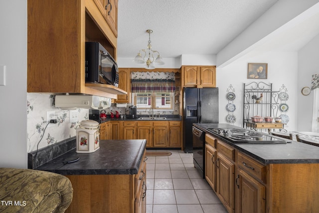 kitchen featuring a kitchen island, sink, a textured ceiling, and black appliances