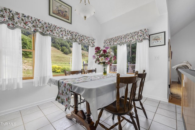 tiled dining space featuring lofted ceiling