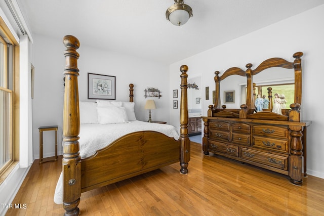 bedroom with multiple windows and light hardwood / wood-style flooring