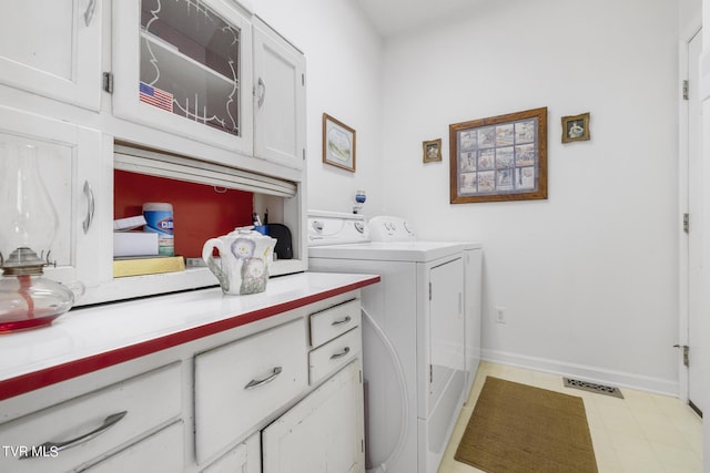 washroom featuring washer and clothes dryer and cabinets