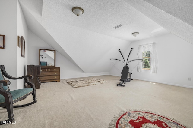 workout area featuring carpet floors, vaulted ceiling, and a textured ceiling