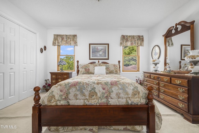 carpeted bedroom featuring multiple windows, a closet, and a textured ceiling