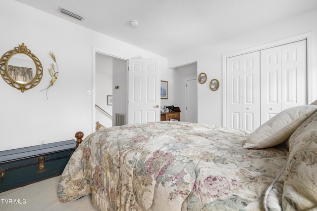 bedroom with carpet floors, a textured ceiling, and a closet