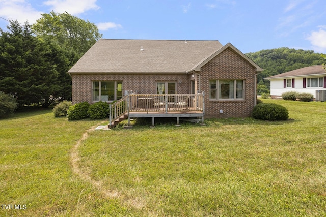 rear view of property with a yard and a deck