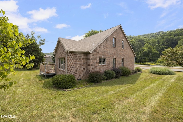 view of side of home featuring a wooden deck and a yard