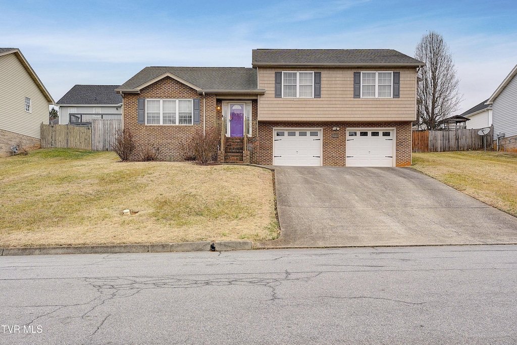 tri-level home featuring a garage and a front lawn