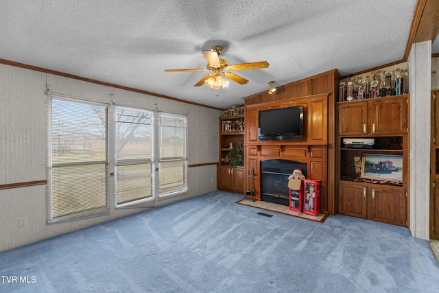 335 Clemon Rd, Whitesburg, TN 37891 - unfurnished living room featuring light carpet, a ceiling fan, a fireplace with flush hearth, ornamental molding, and a textured ceiling
