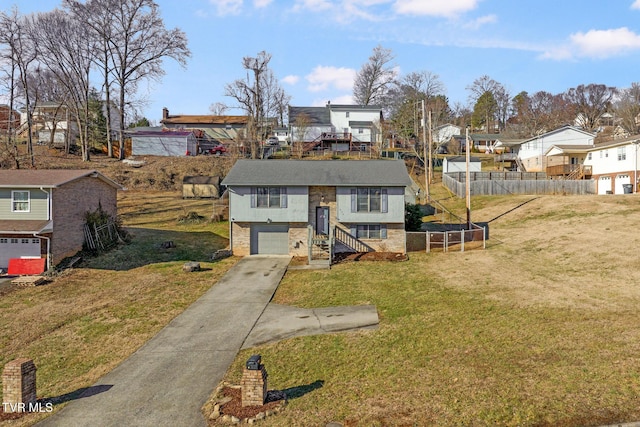 bi-level home with a garage and a front lawn