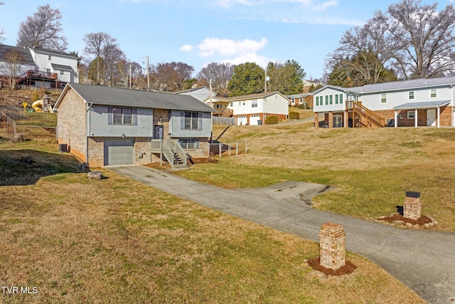 bi-level home with a garage and a front lawn