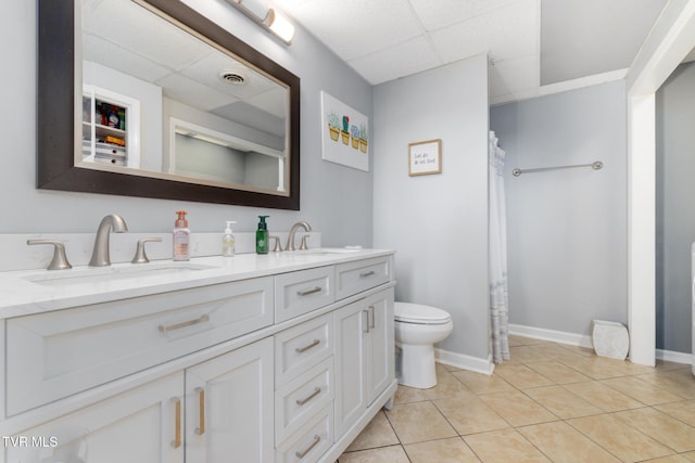 bathroom with vanity, a paneled ceiling, tile patterned floors, and toilet