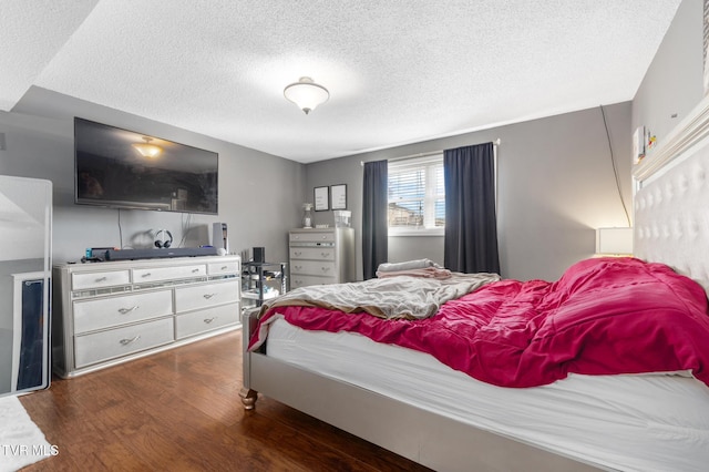 bedroom with dark hardwood / wood-style flooring and a textured ceiling