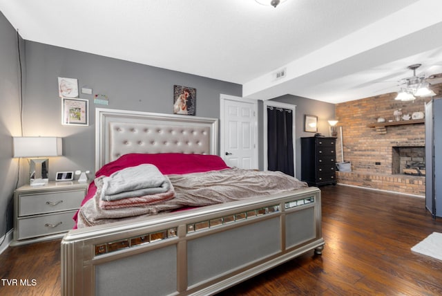 bedroom featuring a fireplace and dark wood-type flooring