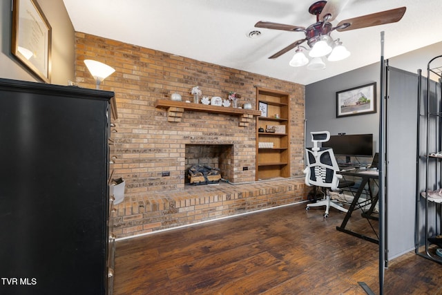 office area featuring ceiling fan, a fireplace, dark hardwood / wood-style flooring, and built in features