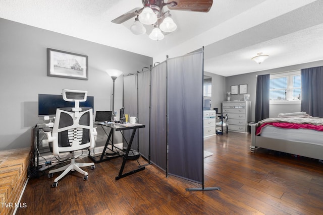 office area with a textured ceiling, dark wood-type flooring, and ceiling fan