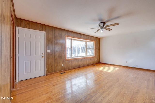 entryway with wooden walls, light hardwood / wood-style floors, and ceiling fan