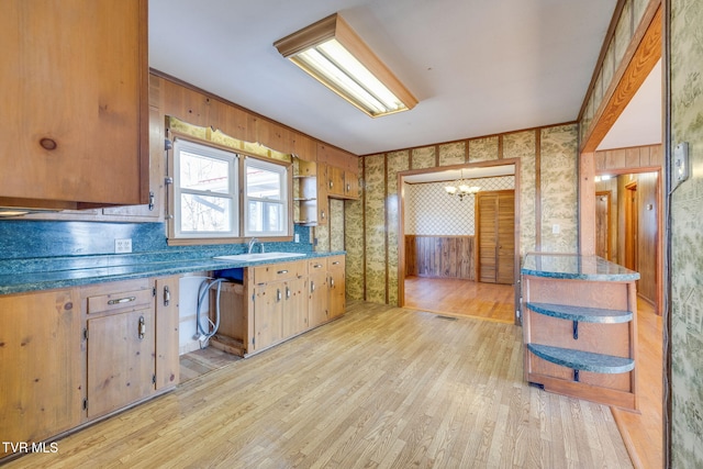 kitchen featuring an inviting chandelier, sink, and light hardwood / wood-style flooring