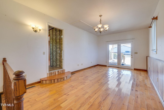 unfurnished living room with a notable chandelier and light hardwood / wood-style flooring