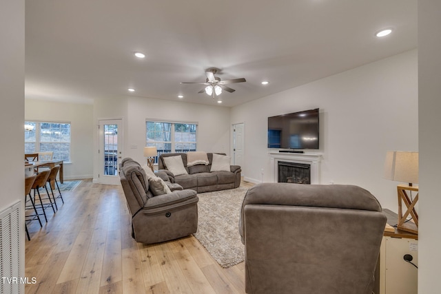 living room featuring ceiling fan and light wood-type flooring