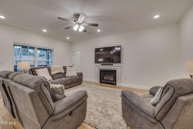 living room featuring ceiling fan and light wood-type flooring