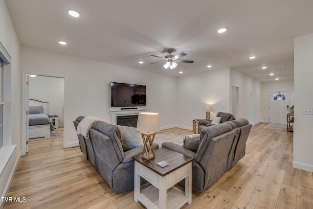 living room with light hardwood / wood-style floors and ceiling fan