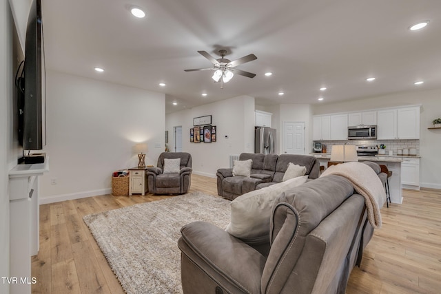 living room featuring ceiling fan and light hardwood / wood-style floors