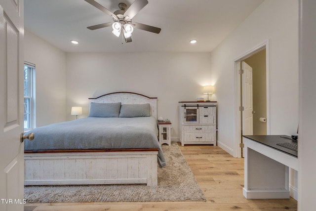 bedroom with light hardwood / wood-style floors and ceiling fan