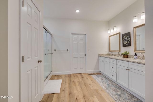 bathroom with vanity, hardwood / wood-style floors, and a shower with shower door