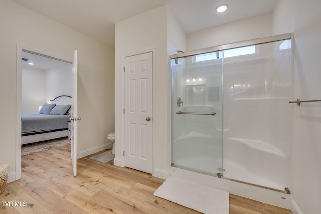 bathroom featuring wood-type flooring, toilet, and walk in shower