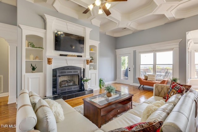 living room featuring beamed ceiling, wood-type flooring, coffered ceiling, and a fireplace