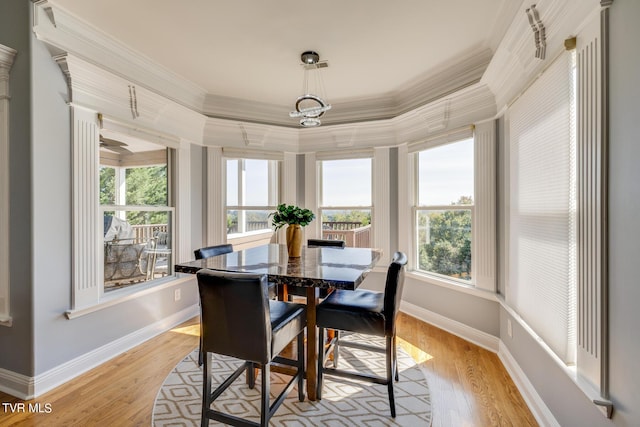 dining space with crown molding, a wealth of natural light, and light hardwood / wood-style flooring