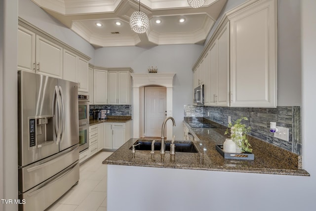 kitchen with sink, stainless steel appliances, decorative light fixtures, kitchen peninsula, and dark stone counters