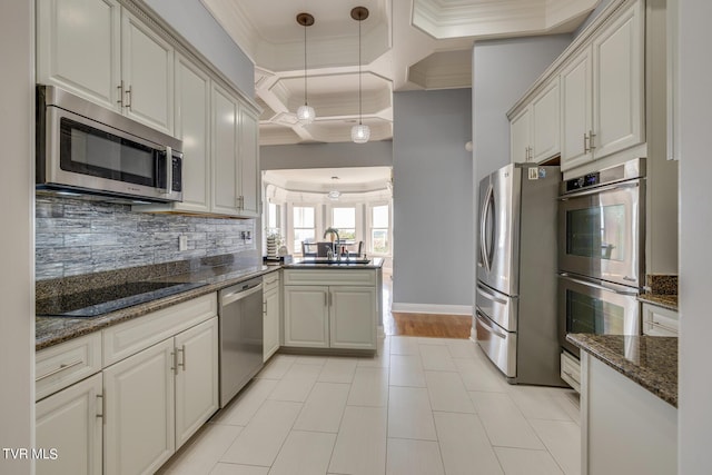 kitchen featuring sink, hanging light fixtures, ornamental molding, kitchen peninsula, and stainless steel appliances