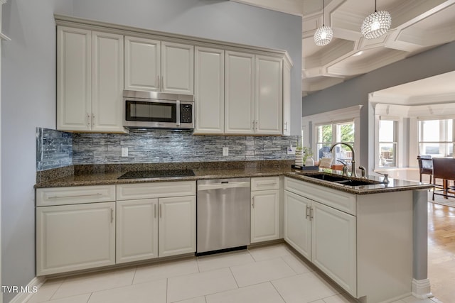 kitchen with appliances with stainless steel finishes, sink, decorative backsplash, and dark stone counters