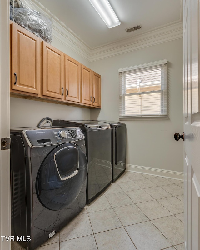 laundry area featuring cabinets, washing machine and dryer, ornamental molding, and light tile patterned floors