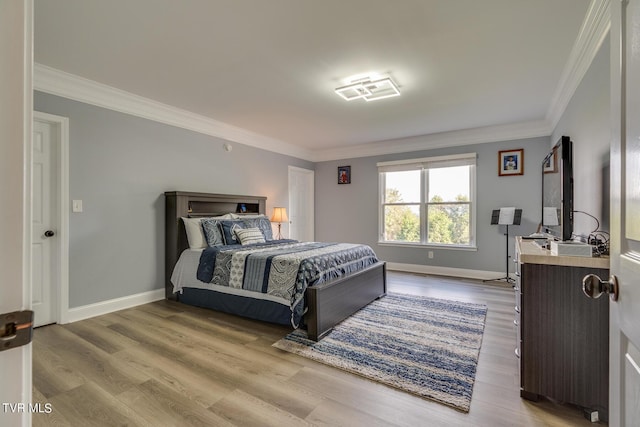 bedroom with crown molding and light wood-type flooring