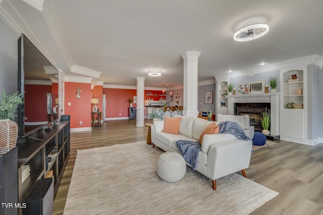 living room featuring crown molding, decorative columns, and hardwood / wood-style floors