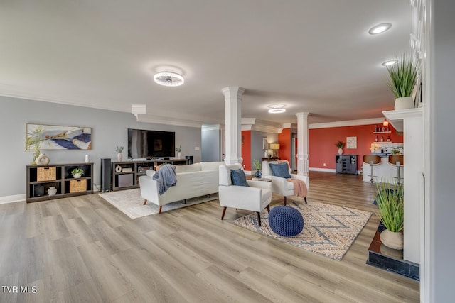 living room with ornamental molding, bar area, light hardwood / wood-style flooring, and ornate columns