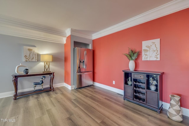 interior space with ornamental molding and hardwood / wood-style floors