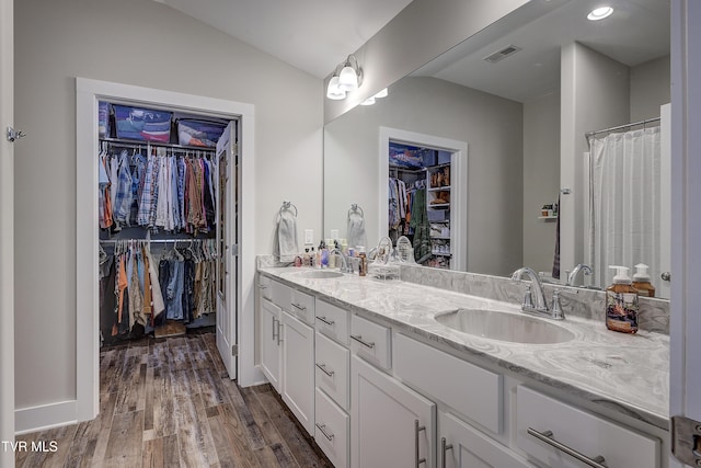 bathroom featuring hardwood / wood-style flooring, vanity, and vaulted ceiling