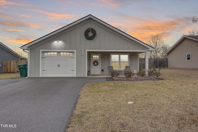 view of front facade featuring a garage, a porch, and a yard